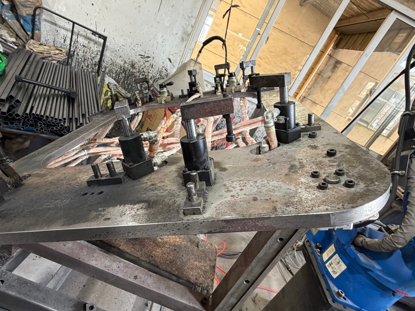 Metal frame furniture manufacturing with fixture-controlled robotic welding for consistent welds and stable bed frame geometry